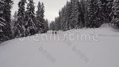 教练和一个初学者滑雪者滑下高山滑雪斜坡